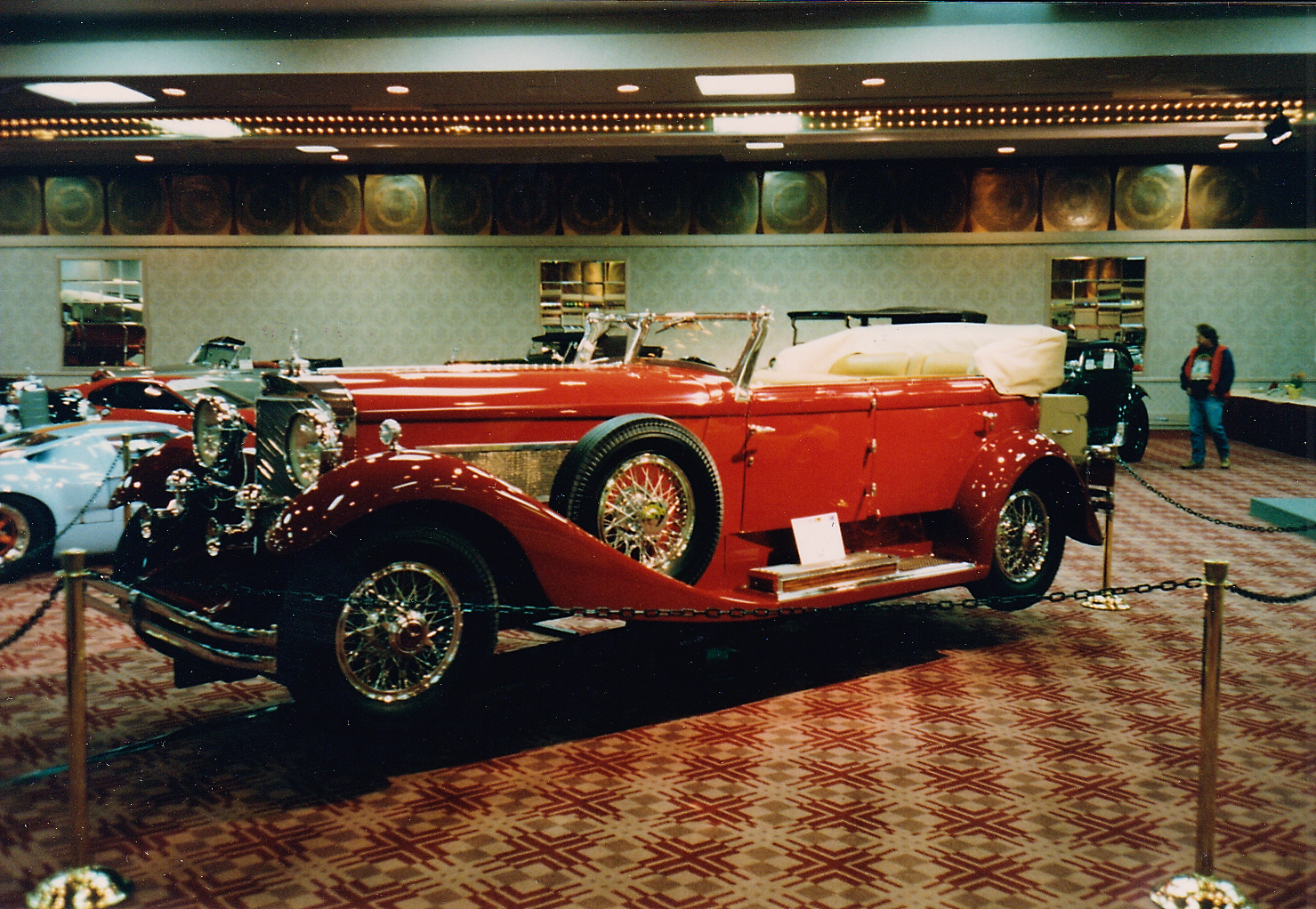 The large red open car looks like a Duesenberg, but I believe it was a Mercedes (check the grille).